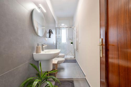 a bathroom with two toilets and a sink and a mirror at Miki's Home in Bari