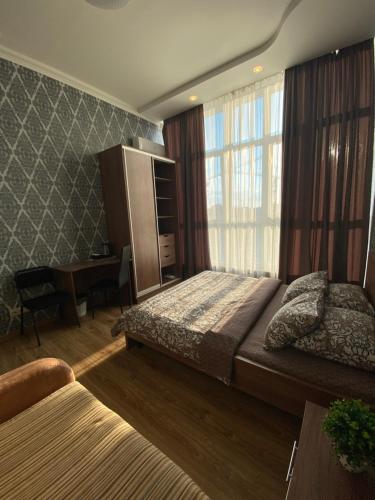 een slaapkamer met 2 bedden, een bureau en een raam bij Sweet2sleep in Kiev
