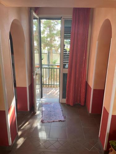 un corridoio con porta aperta su un balcone di CasAle a Borgetto