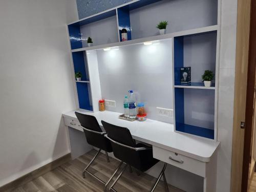 a white desk with two chairs in a room at 2BHK fully furnished apartment in Indore