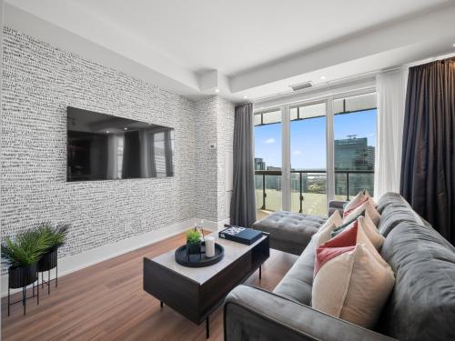een woonkamer met een bank en een bakstenen muur bij Stylish One Bedroom Suite - Entertainment District Toronto in Toronto