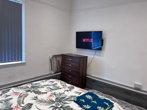 a bedroom with a bed and a tv on the wall at Studio Flat with Kitchenette in Birmingham