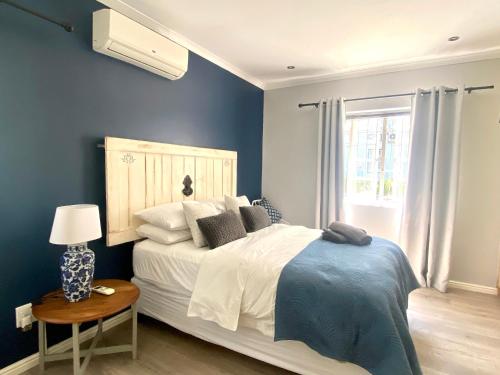a bedroom with a large bed and a window at Stay on Main - Studio Blue in Paarl