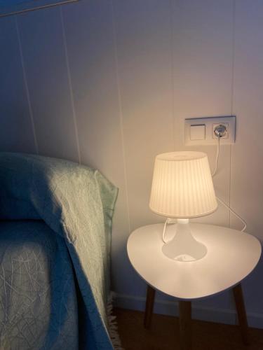 a lamp on a table next to a bed at TU ESCONDITE in Jerez de la Frontera