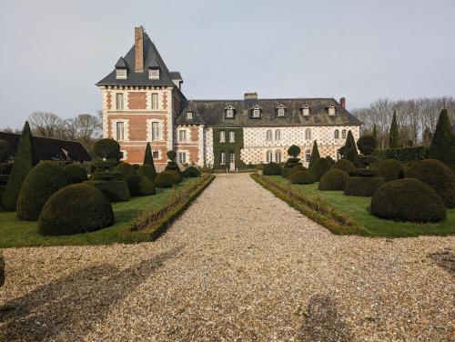 une grande maison avec un jardin devant dans l'établissement Domaine du Bosc Roger, à Bouquetot