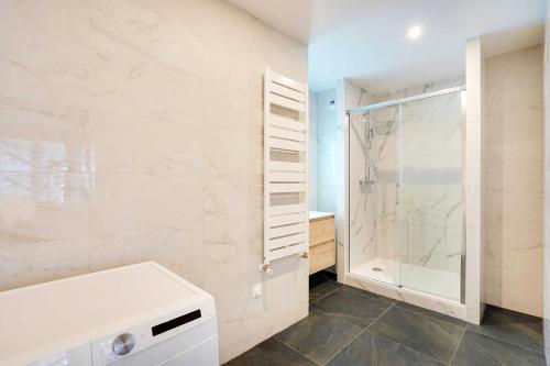 ein Bad mit einer Dusche und einem weißen Waschbecken in der Unterkunft Raffinement et Confort dans cette Résidence à Levallois-Perret in Levallois-Perret