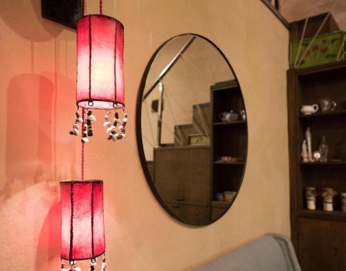 zwei rote Lichter an einer Wand neben einem Spiegel in der Unterkunft Casa Rural La Cepedana in Cogorderos