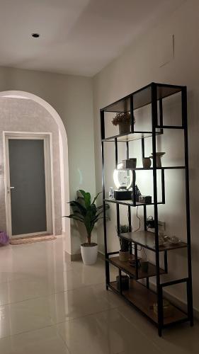 a room with a shelf with a plant and a door at شقه فاخره in Unayzah