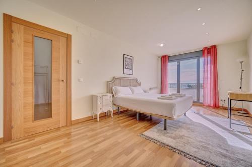 a bedroom with a bed and a desk and a window at Casa Viana by Clabao in Viana