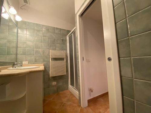 La salle de bains est pourvue d'un lavabo et d'une douche. dans l'établissement Attico con vista mozzafiato ! Golfo di Marinella, à Golfo Aranci