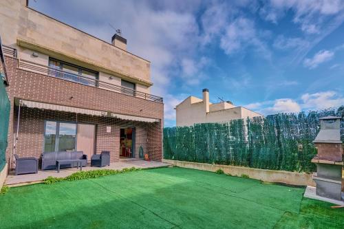 um quintal com um relvado verde e um edifício de tijolos em Casa Viana by Clabao em Viana