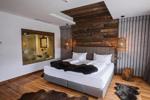 a bedroom with a large bed and a mirror at HANUL BUCOVINEI in Câmpulung Moldovenesc
