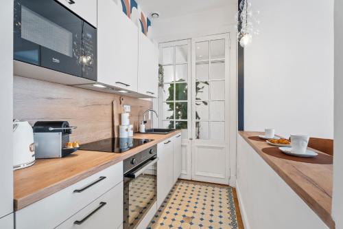 une cuisine avec des armoires blanches et un comptoir dans l'établissement Nice Renting - FOCH - Luxury Bourgeois & Design at the Heart of Nice, à Nice