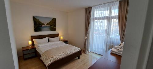 een slaapkamer met een bed en een groot raam bij Westpark Apartments in München