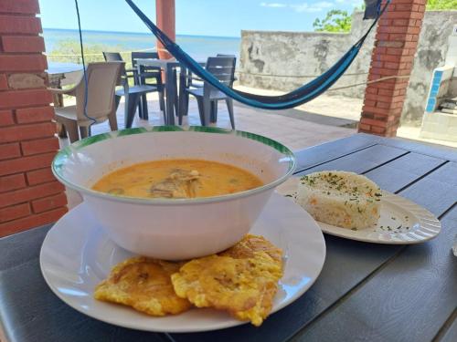 Horizonte Azul في Casares: وعاء من الحساء وصحنين من الطعام على طاولة