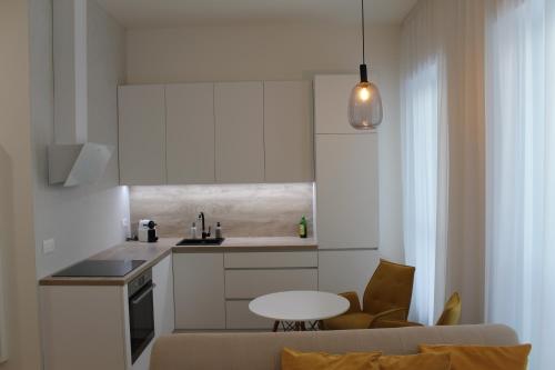 a kitchen with white cabinets and a table in a room at Park Tower apartment v centru Zlína in Zlín