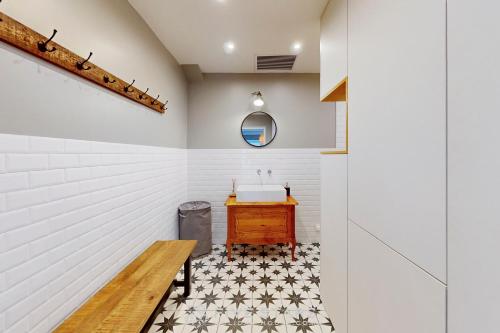 La salle de bains est pourvue d'un lavabo et d'un banc en bois. dans l'établissement Villa La Roche aux Mouettes FSHH, à Nice