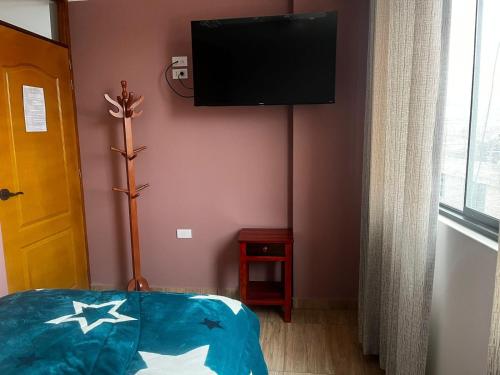 Pokój z telewizorem na ścianie i łóżkiem w obiekcie HOSTAL SANTA ISABEL-JAUJA w Jauja