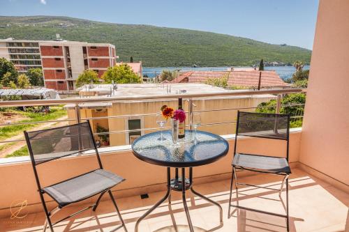 einen Glastisch und zwei Stühle auf dem Balkon in der Unterkunft Apartment Rosemary - Happy Rentals in Herceg-Novi