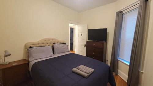 a bedroom with a large bed with a blue blanket at Chateau de Woodlawn - Peaceful 3 bedroom apartment. in Chicago