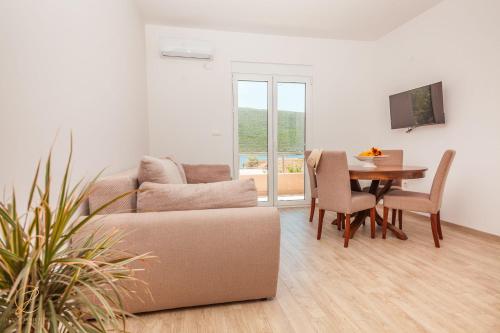 ein Wohnzimmer mit einem Sofa und einem Tisch in der Unterkunft Apartment Rosemary - Happy Rentals in Herceg-Novi