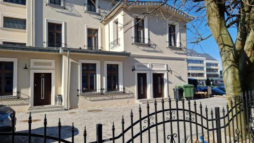a white house with a fence in front of it at APARTAMENT JARACZA 28/12 in Słupsk