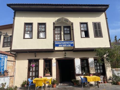 a building with tables and chairs in front of it at Dedehan Pansiyon in Antalya