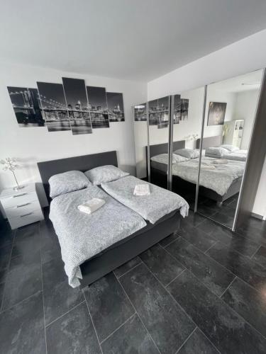a bedroom with two beds and mirrors on the wall at Exklusive Moderne Wohnung Gießen Stadtnähe mit Balkon in Annerod