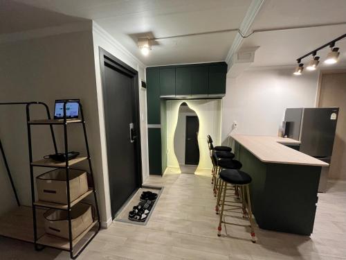 a kitchen with a counter and stools in a room at Green house room 102 in Seoul