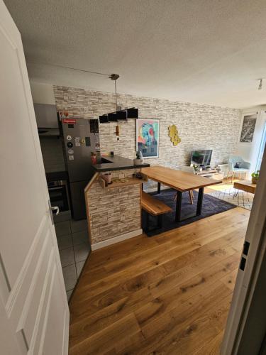 L'hippique - Parking - vue Pyrénées - Balcon في بو: مطبخ مع طاولة خشبية في الغرفة