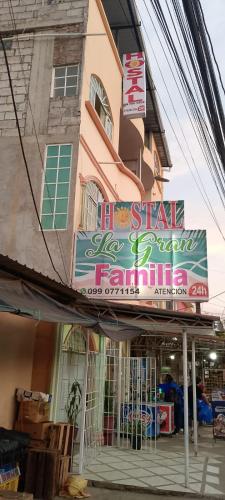 曼塔的住宿－Hostal La GRAN Familia，商店前有标志的建筑物