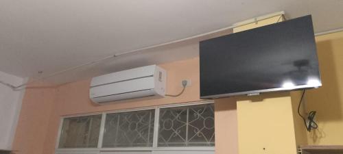 uma televisão de ecrã plano pendurada numa parede em Hostal La GRAN Familia em Manta