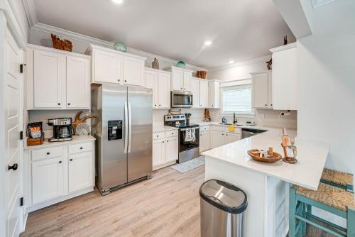 a kitchen with white cabinets and a stainless steel refrigerator at Near State Parks Carrabelle Home with Beach Access! in Big Blackjack Landing