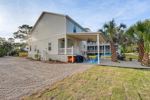 a white house with palm trees in front of it at Near State Parks Carrabelle Home with Beach Access! in Big Blackjack Landing