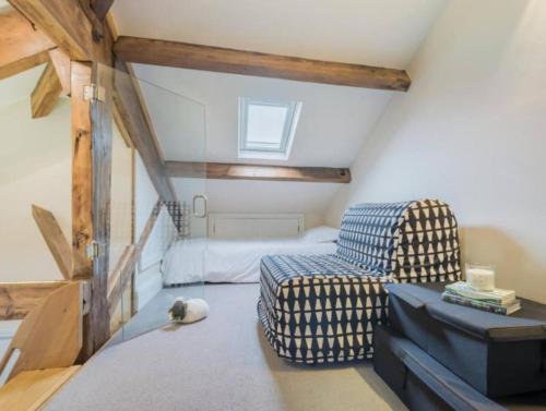 a attic room with a bed and a chair at The Penthouse - in the heart of Sedbergh in Sedbergh