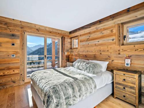 1 dormitorio con paredes de madera, 1 cama y ventana en Outstanding 3 bedroom chalet Koch by Dieckereise, en Verbier