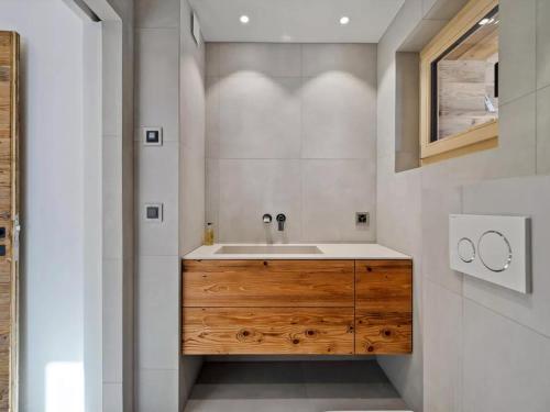baño con lavabo y armario de madera en Outstanding 3 bedroom chalet Koch by Dieckereise, en Verbier