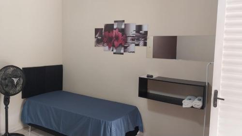 a room with a blue bed and a fan at Pousada Beija flor in Extrema