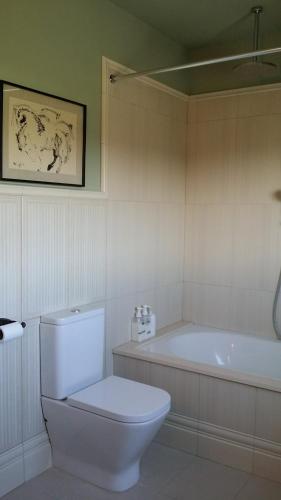 ein weißes Bad mit einem WC und einer Badewanne in der Unterkunft LARGE HOUSE & POOL near the beach and Barcelona in Alella