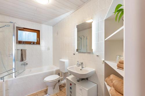 a white bathroom with a sink and a toilet at Ferienwohnung Brigitte in Forbach
