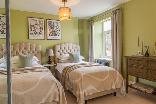two beds in a bedroom with green walls at Bert's Place in Chipping Norton