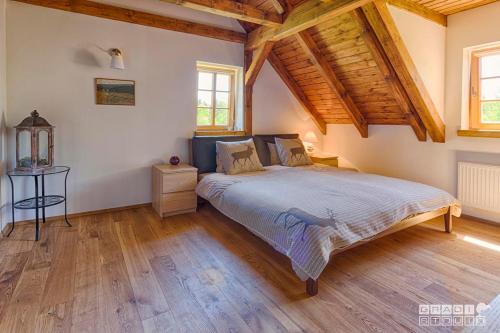 um quarto com uma cama num quarto com tectos em madeira em Chalupa U tří zajíců em Albrechtice v Jizerskych horách