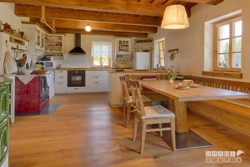 uma grande cozinha com uma mesa de madeira e cadeiras em Chalupa U tří zajíců em Albrechtice v Jizerskych horách