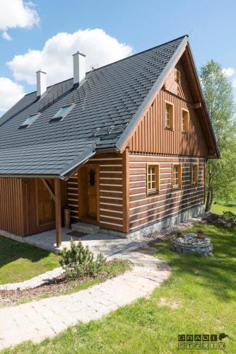 una gran casa de madera con techo de gambrel en Chalupa U tří zajíců, en Albrechtice v Jizerských horách