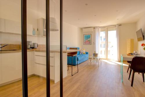 Il comprend une cuisine et un salon doté d'un canapé bleu. dans l'établissement Cannes Croisette - 4 Personnes - Vue mer, à Cannes