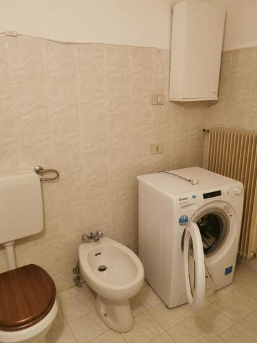 a bathroom with a washing machine and a toilet at Casa Viarago in Pergine Valsugana