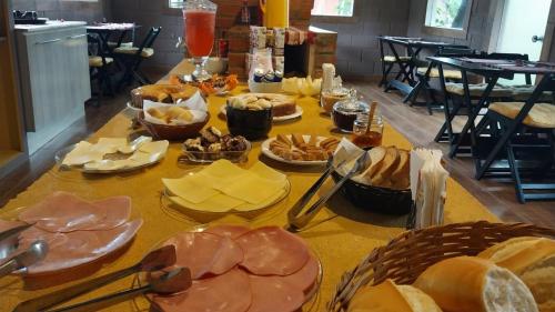 einen Tisch mit vielen verschiedenen Lebensmitteln in der Unterkunft Pousada Beija flor in Extrema