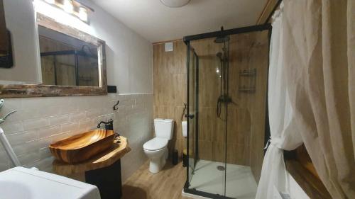 y baño con aseo y ducha con bañera de madera. en Jaśkowa Stodoła, en AdamÃ³w