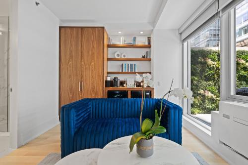 a living room with a blue couch and a table at The Gotham Hotel in New York