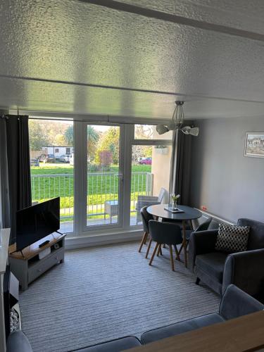 a living room with a couch and a table and chairs at Dawlish Warren Apartment in Dawlish